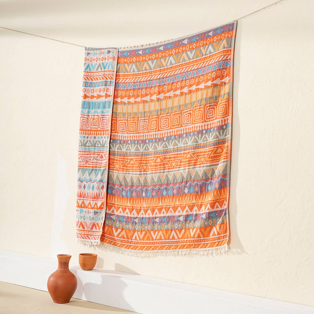 Ethnic Turkish cotton throw blanket – tribal stripe, Orange, styled on a wall | Kikoya