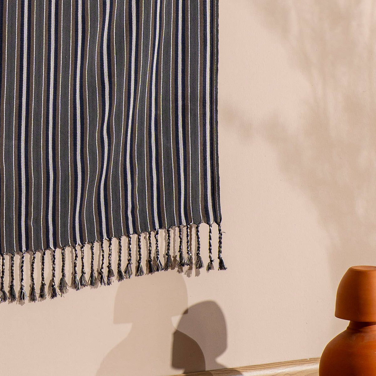 Graphite pinstripe Turkish towel draped with tasselled edge in sunlight | Kikoya