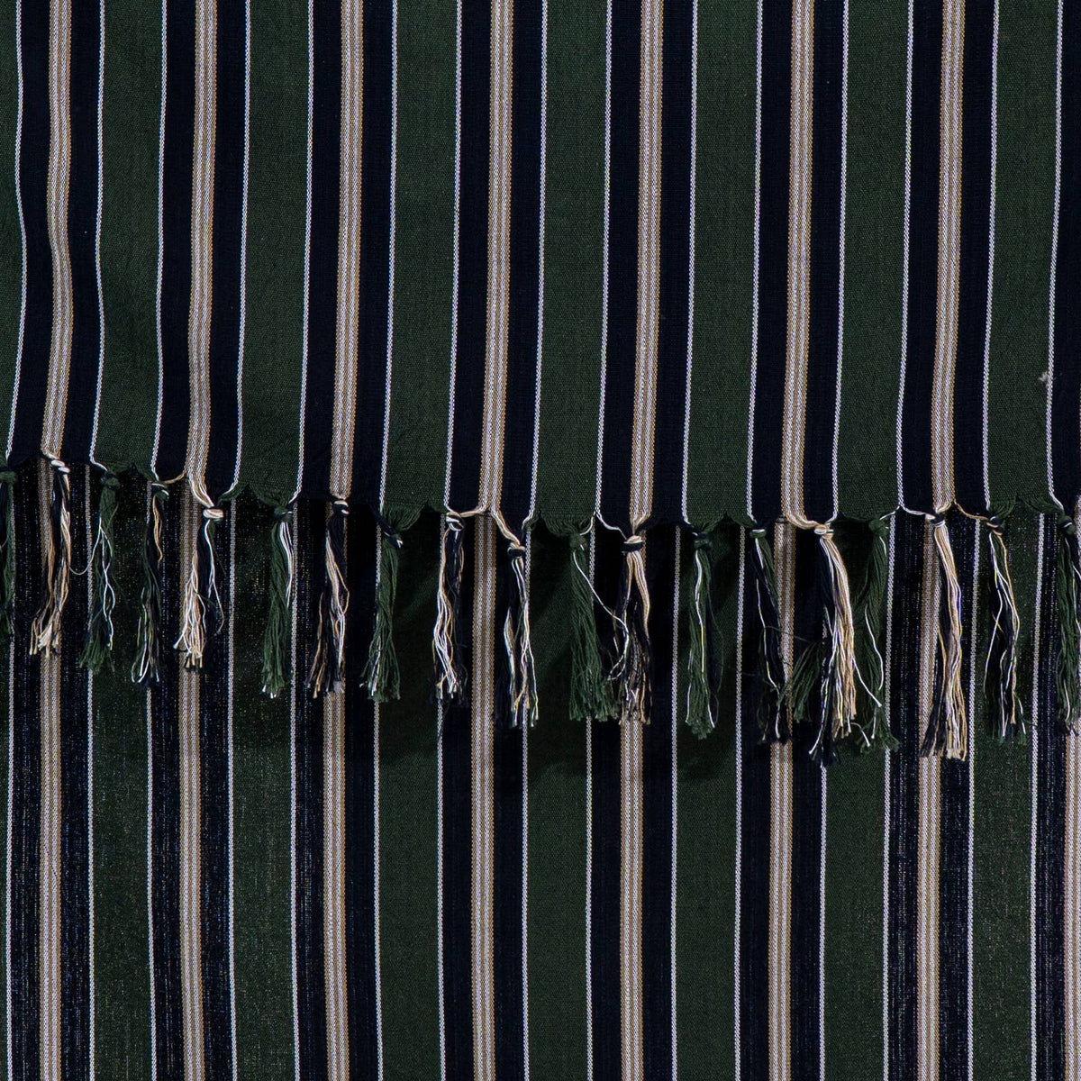 Close-up of the rustic flat weave and knotted tassel fringe on the forest green peshtemal | Kikoya