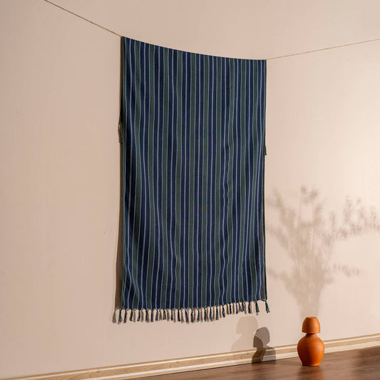 Ink navy pinstripe Turkish peshtemal hanging against a warm wall, 40x70 in | Kikoya