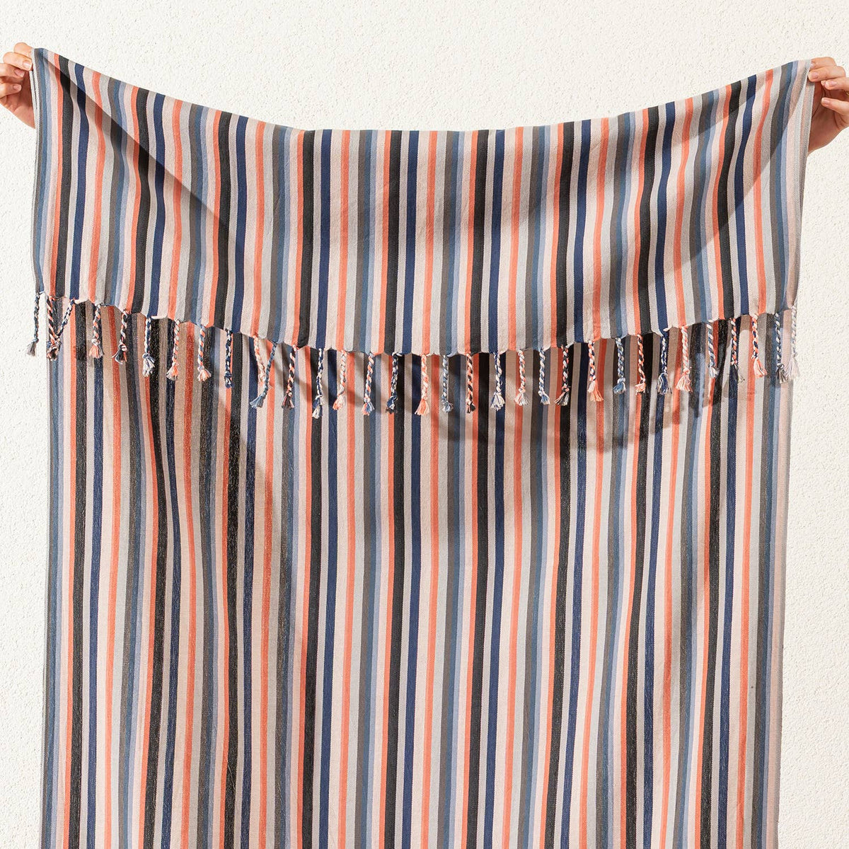 Hand-knotted fringe detail on the terracotta and blue stripe Turkish towel | Kikoya
