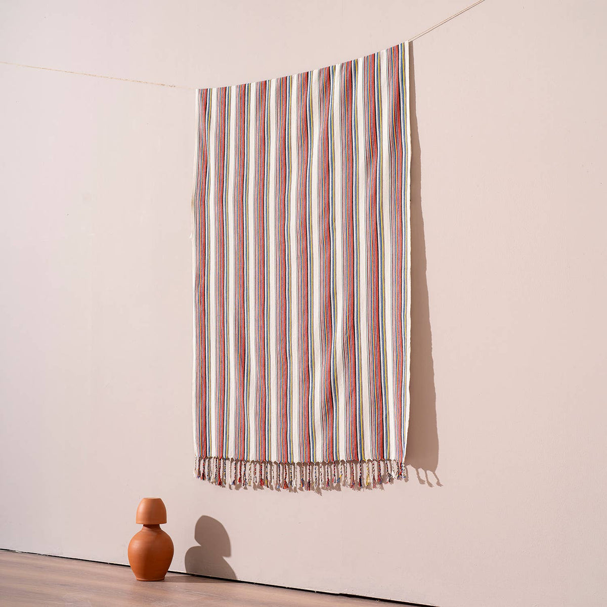 Bazaar stripe Turkish beach towel hung against a warm wall | Kikoya