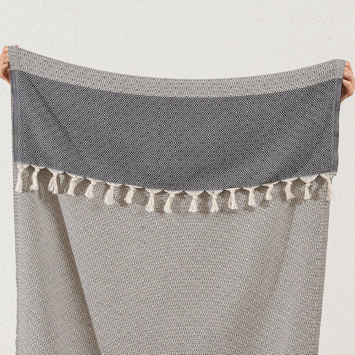 Black Topkapi diamond weave Turkish towel held open to show the plain end band | Kikoya