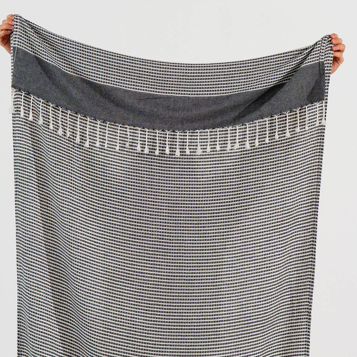 Black Efes Turkish towel held open showing the fine stripe weave | Kikoya